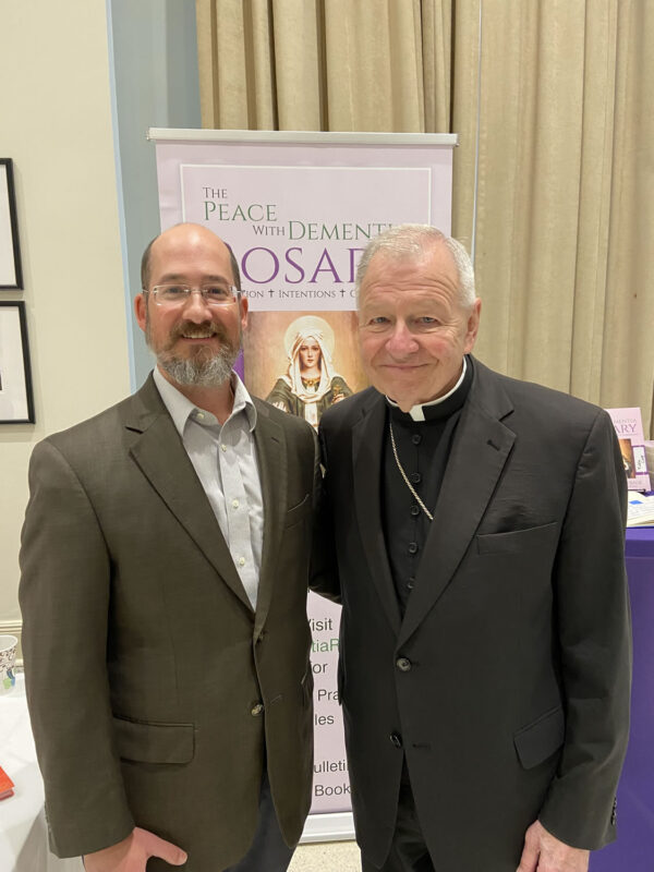 Matthew Estrade with Archbishop Gregory M. Aymond at a Catholic healthcare conference.